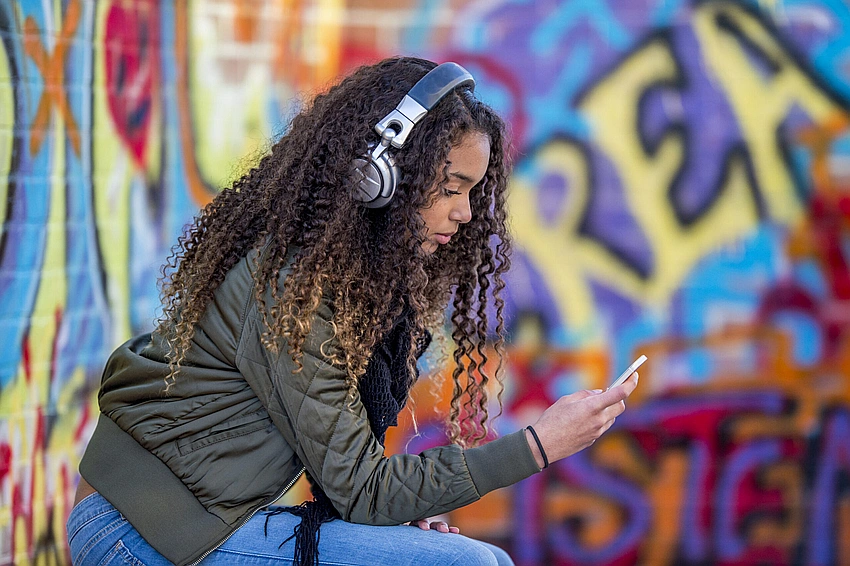 Gen Z listening to music, headphones, introspective, urban glow