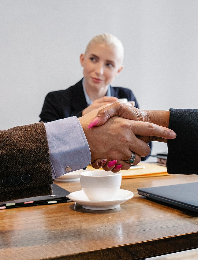 Person confidently shaking hands in an interview, modern office, Pexels photo