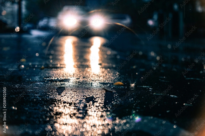 headlights on dark road rain