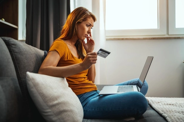 Person sadly shopping online on a couch