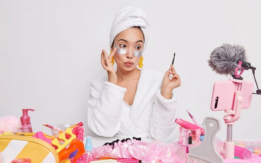 young woman looking overwhelmed by many skincare products on a vanity