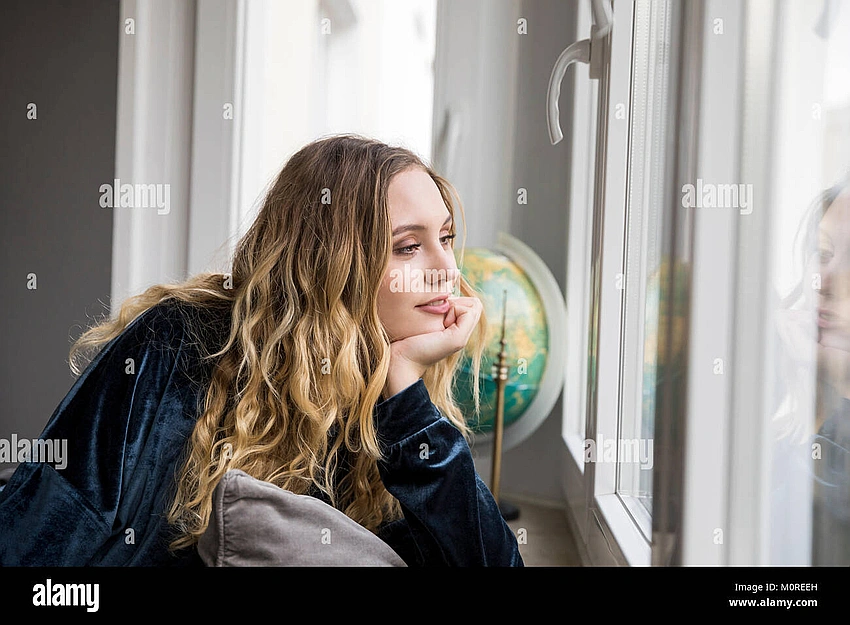 woman daydreaming looking out window, creative space