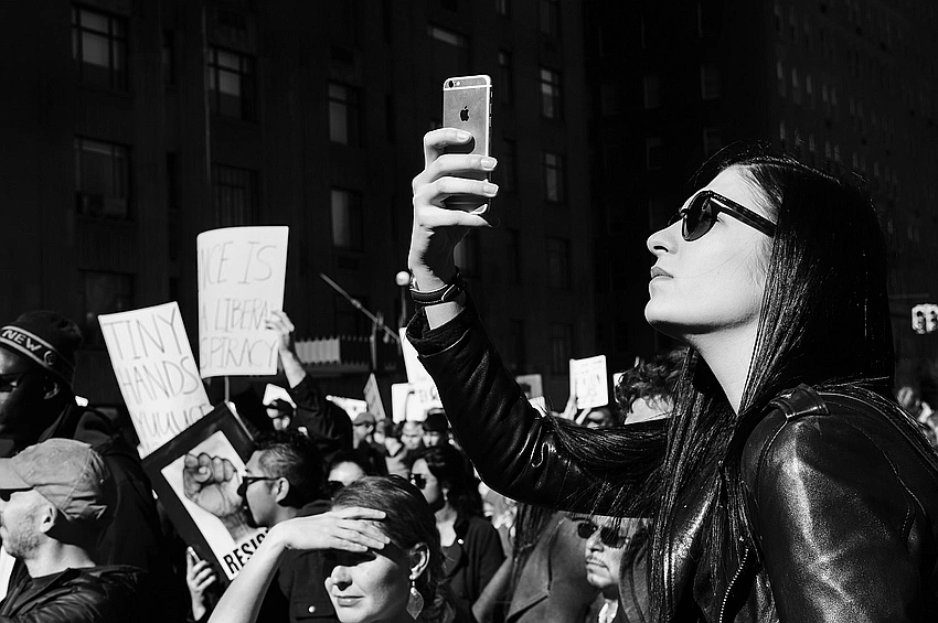 historical protest black and white, modern smartphone scrolling
