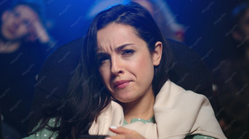 Disappointed woman looking at movie poster with book in hand