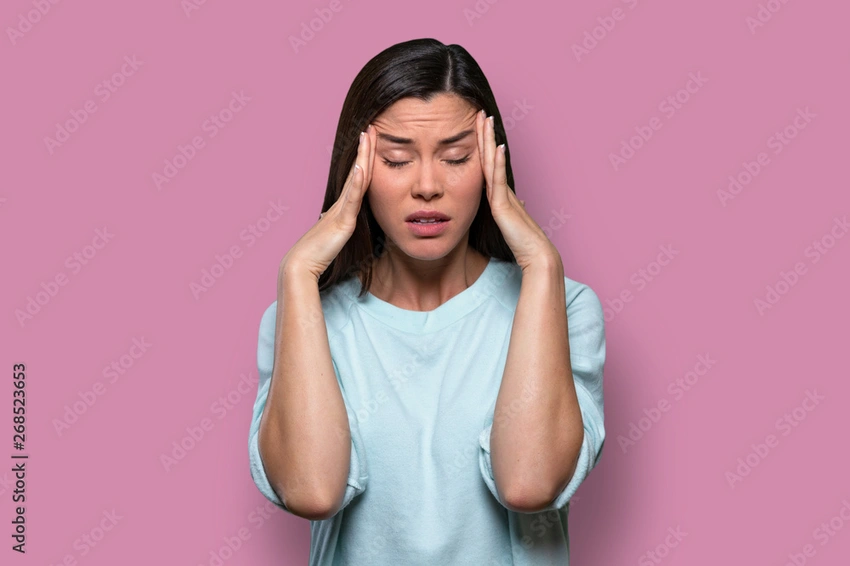 Woman feeling overwhelmed by emotions, head in hands