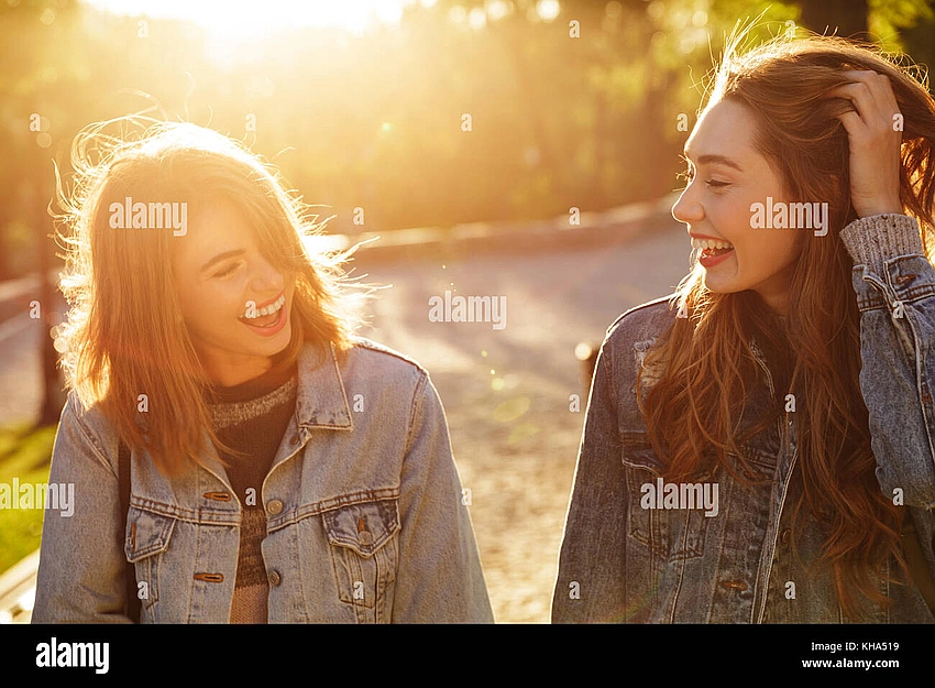 two friends laughing in a sunny park